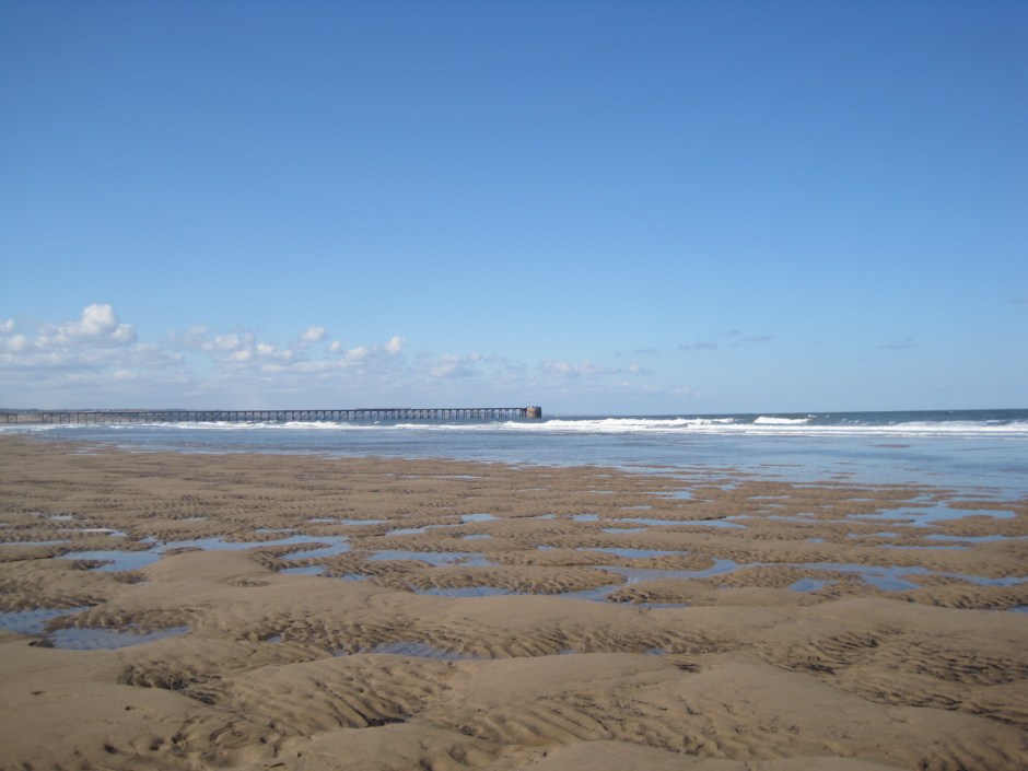 The beach at Hartlepool Headland and derelict pier in the background
