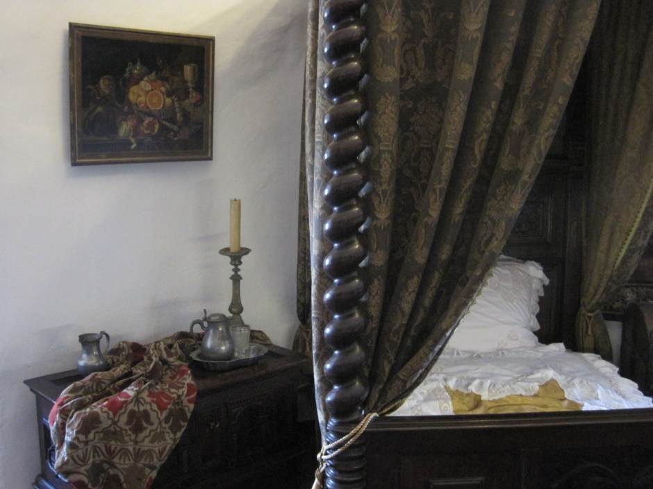 With warm drapes around the bed